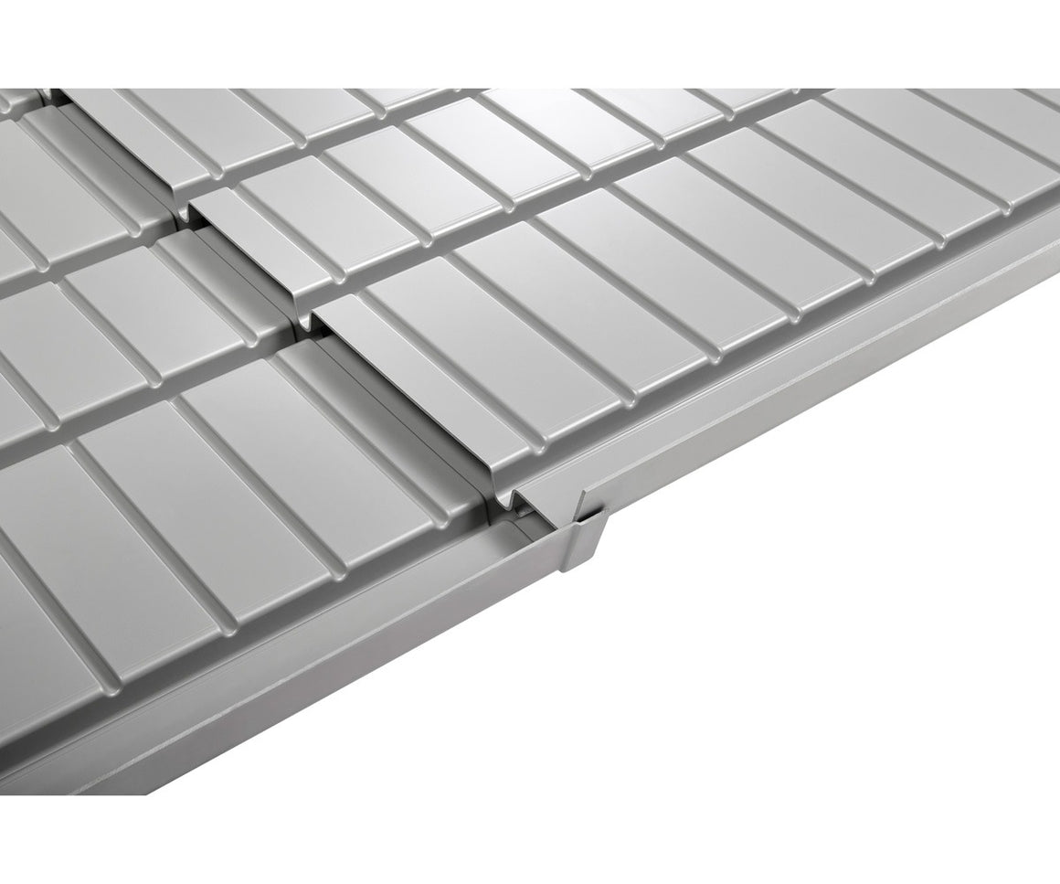A close-up, angled view of a grey hydroponic tray with multiple channels and a drainage gutter.