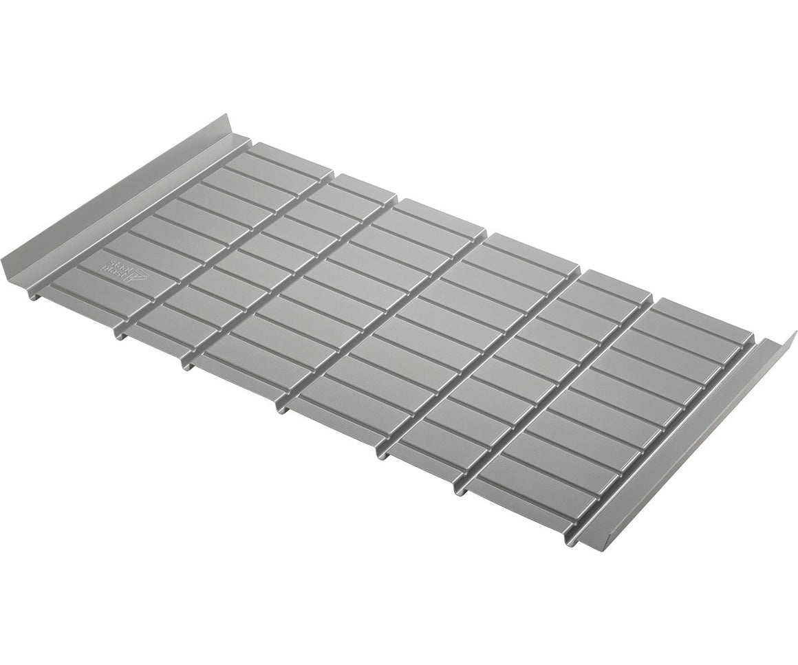 Silver metal drain grate with a ribbed surface and raised edges.