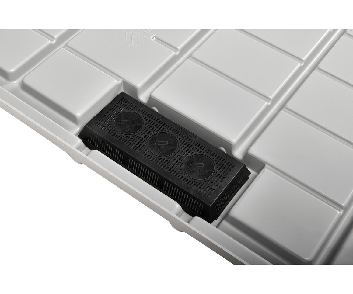 Close-up of a black plastic insert with three circular vents set into a grey, grid-patterned surface.