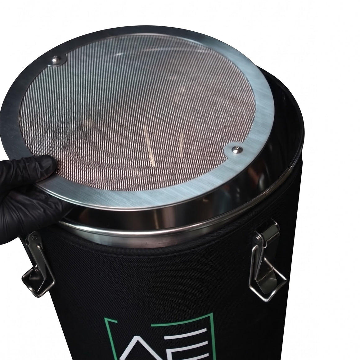 Black hash washer with stainless steel lid. A person in a black glove holds the lid.