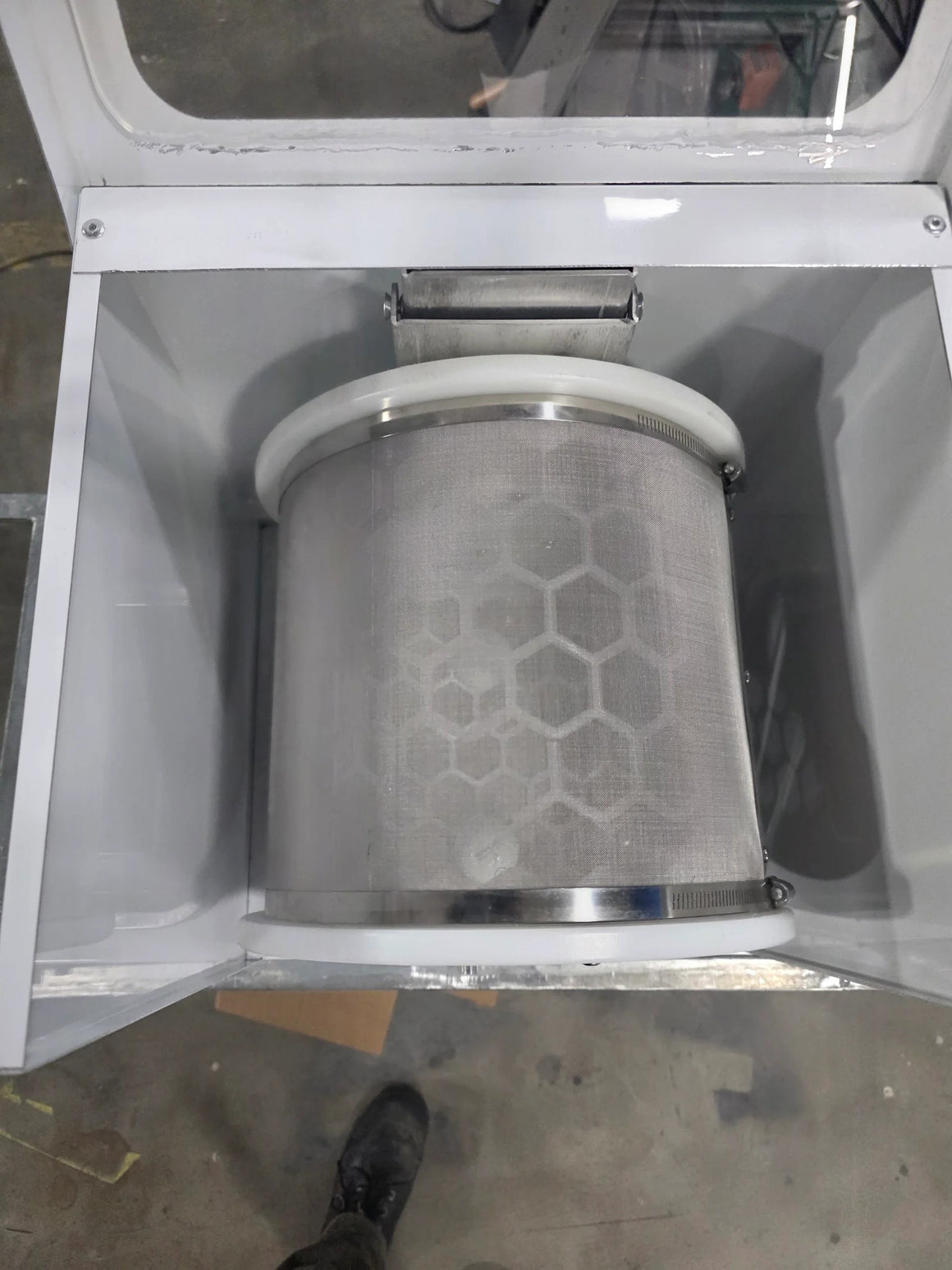 Amped Mini Extraction Tumbler: A metallic mesh cylinder with a honeycomb pattern, housed in a white machine.