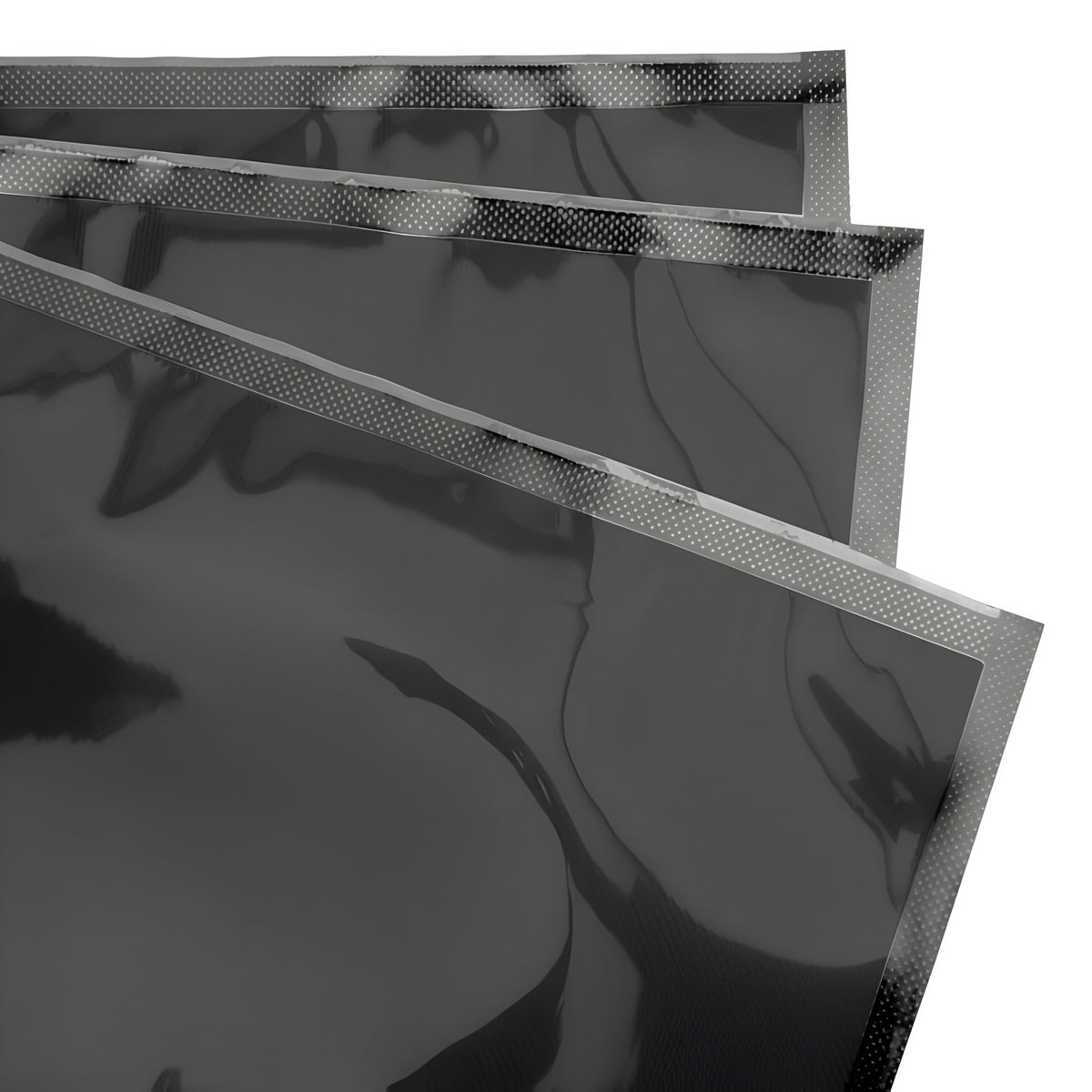Black vacuum seal bags with a patterned edge, stacked against a white background.