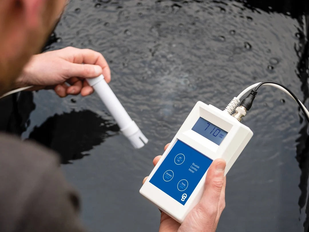 Person testing water with a Bluelab Combo Meter, displaying 7.10.