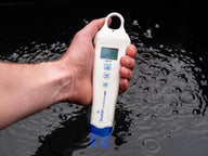 Bluelab conductivity pen with blue tip submerged in dark water with ripples.