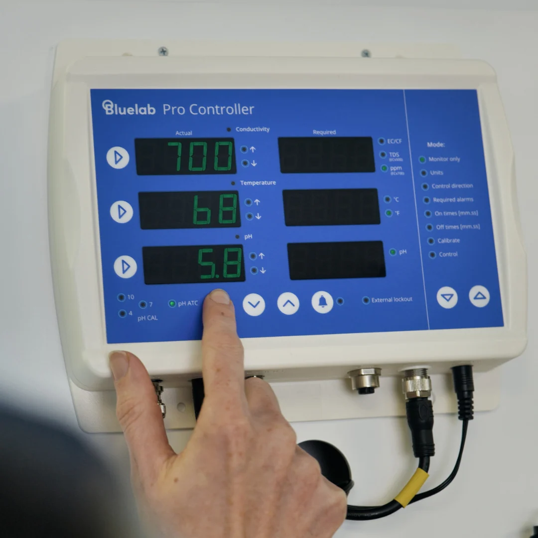 Bluelab Pro Controller with hand touching pH 5.8 display.
