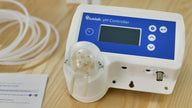 Bluelab pH Controller Wi-Fi with cable and manual on wooden table.