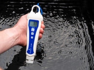 Bluelab pH pen measures 5.7 pH and 20°C in dark water, held by a hand.