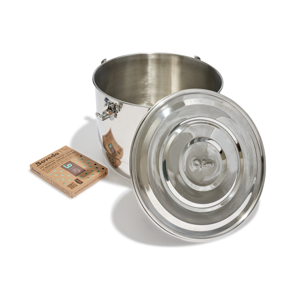 Boveda CVault 2lb stainless steel humidity-controlled storage container with lid off, beside Boveda packs.