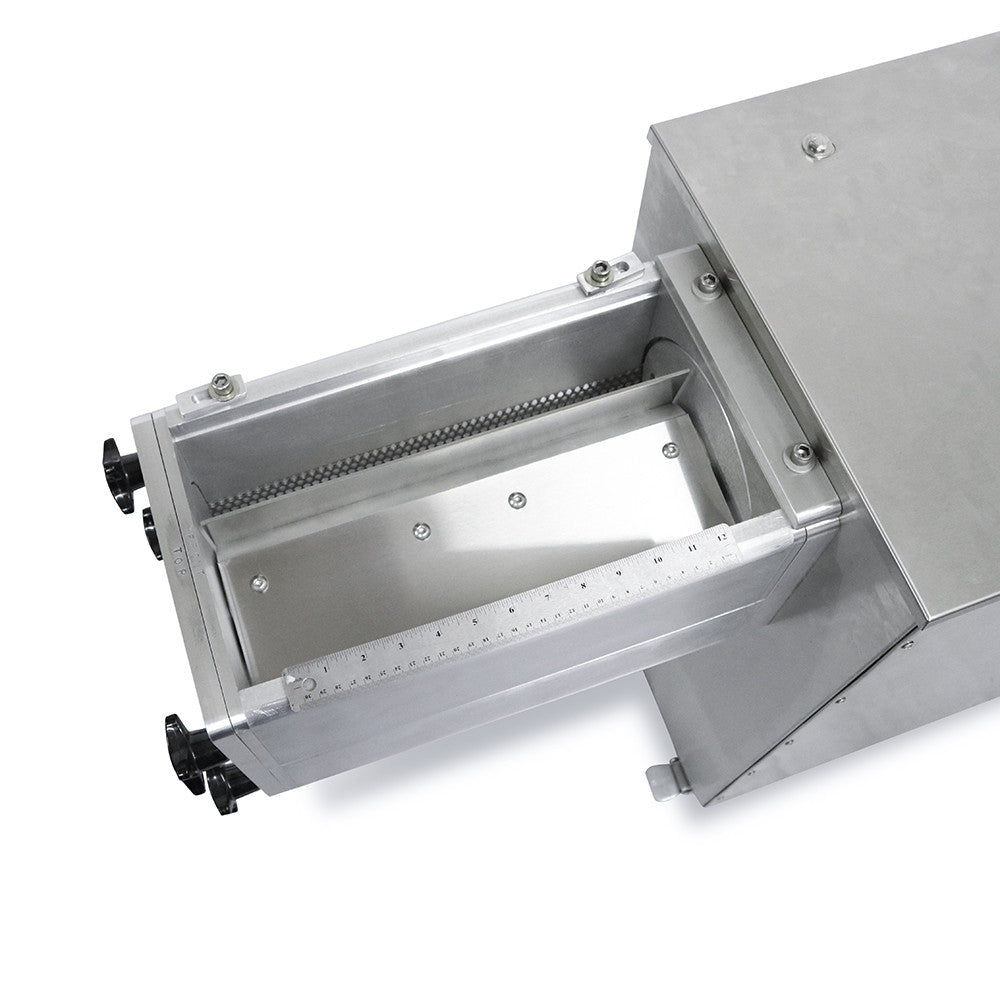 Stainless steel industrial grinder drawer with ruler measurement markings.