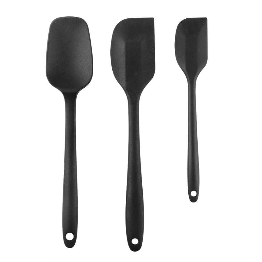 Three black silicone spatulas of varying sizes and shapes on a white background.