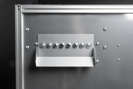 Silver machine panel with multiple metal nozzles and a tray.