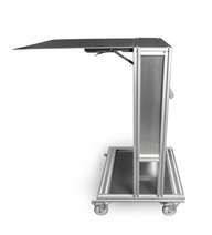 A side view of a rolling silver utility cart with a black tray on wheels.
