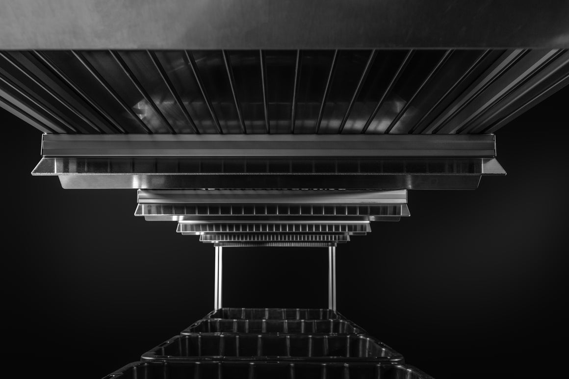Black and white shot of stacked metal trays forming an abstract perspective.