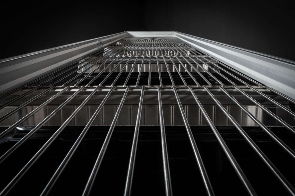 Abstract shot of a metal grate, perspective from below looking up.