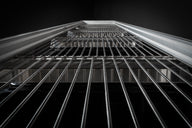 Abstract shot of a metal grate, perspective from below looking up.