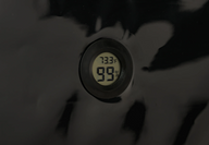Digital hygrometer displaying 73.3°F and 99% humidity on a black surface.