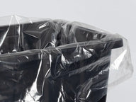 Clear plastic tote liner draped over the rim of a black 27-gallon tote.