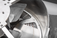 Close-up of a commercial bud trimmer's stainless steel blades and grates.