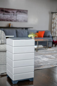 Modern white air purifier in living room on dark wood floor.