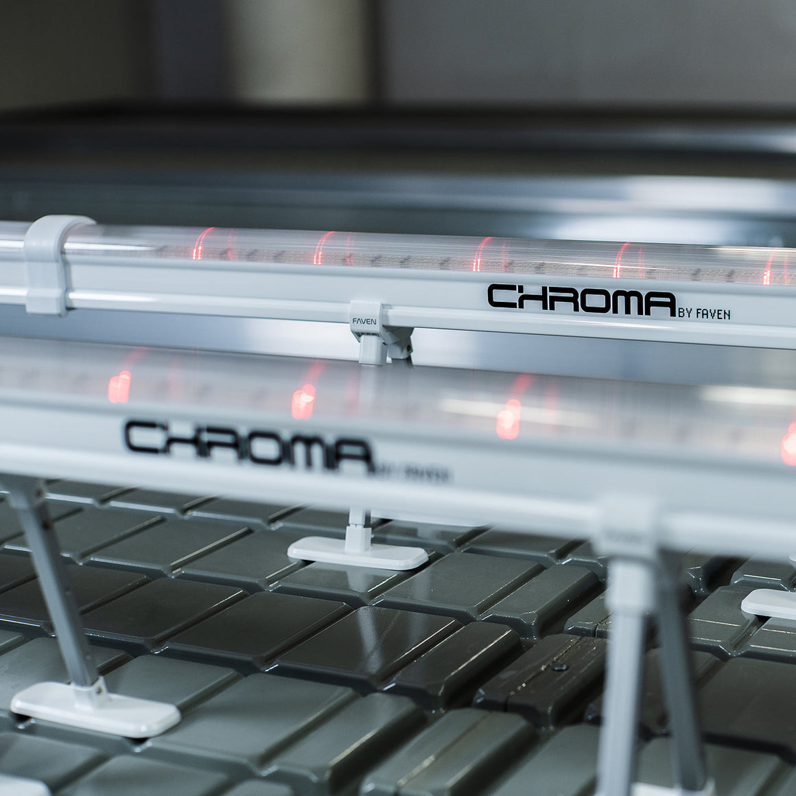 "Chroma by Faven" logo on a lighting bar with red LEDs over a gray tiled surface.
