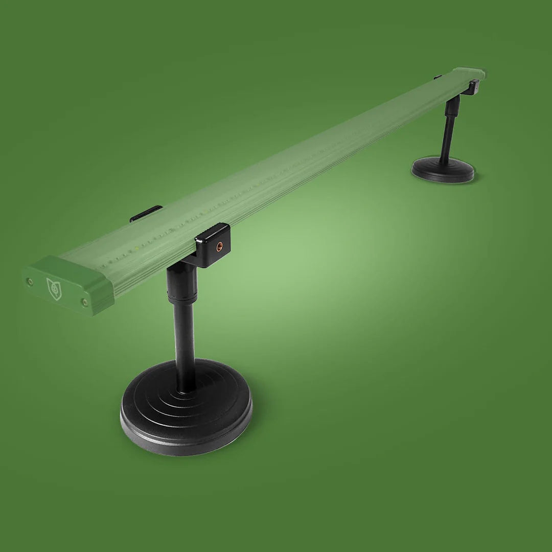 Green rectangular LED grow light bar on two black adjustable stands with round bases, from above.