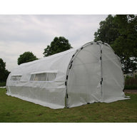 Heavy-duty white greenhouse hoop house with roll-up windows, set on green grass.