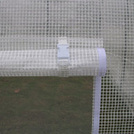 Close-up of a white plastic greenhouse fabric with a rolled-up section secured by a white buckle and strap.