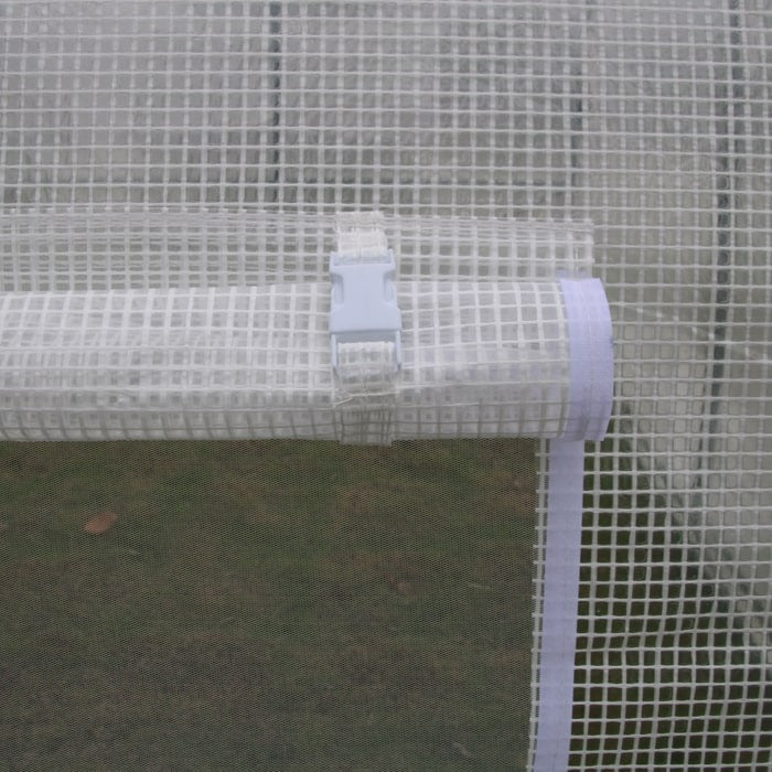 Close-up of a white mesh greenhouse flap rolled up and secured with a plastic buckle and velcro strap.