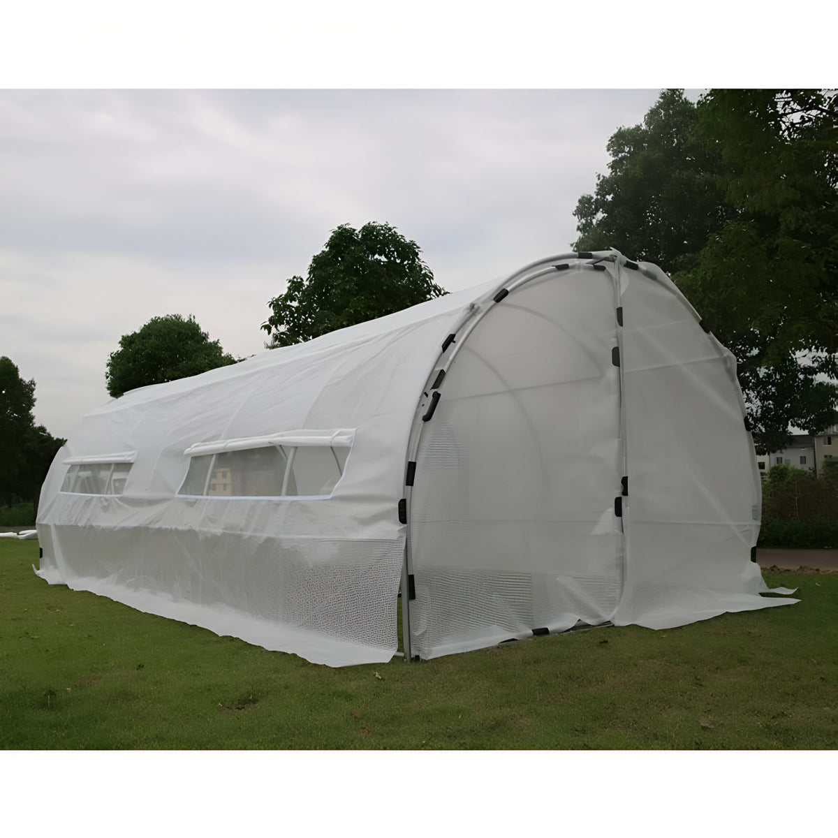 White hoop house greenhouse replacement cover with windows and a roll-up door on a grassy lawn.