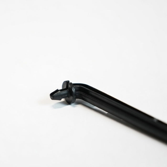 Angled black barbed drip stake on a white background.