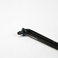 Angled black barbed drip stake on a white background.