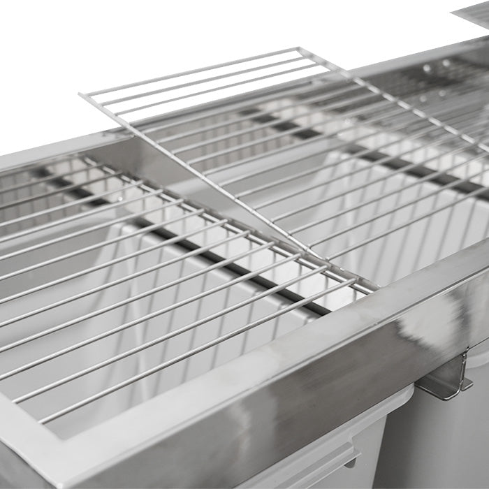 Top-down close-up of a stainless steel harvest sorting system with metal grates, one lifted, and collection bins.