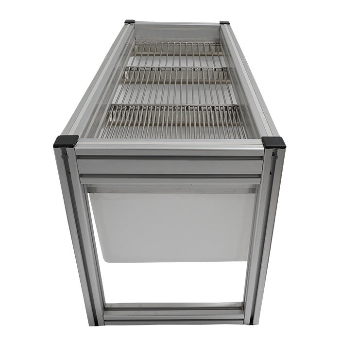 Side view of a small stationary harvest sorting system with aluminum frame, metal grates, and white collection tray.