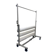 A cannabis trellis netting system with three rolls of white netting on a wheeled aluminum frame.