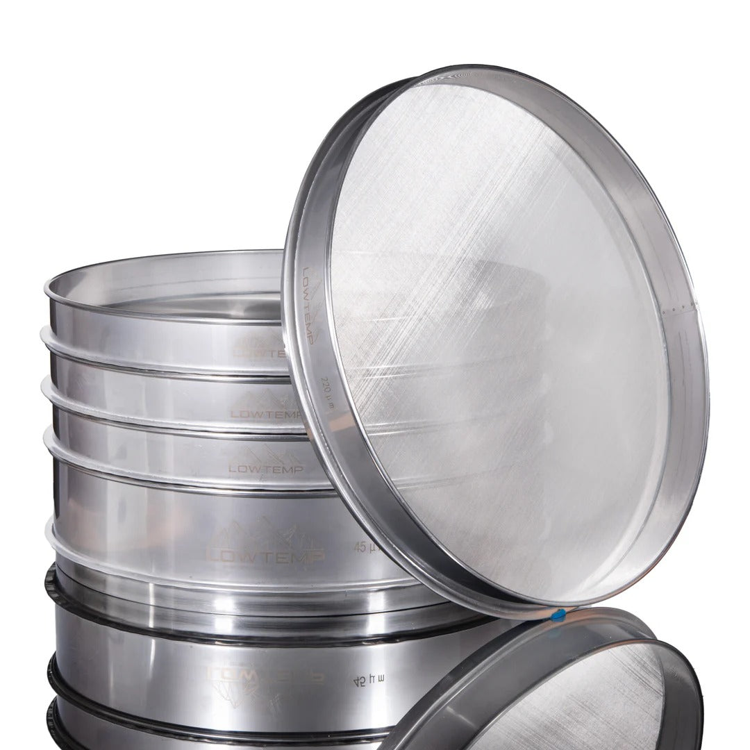 Stack of stainless steel sieves with fine mesh screens, some labeled "LOWTEMP".
