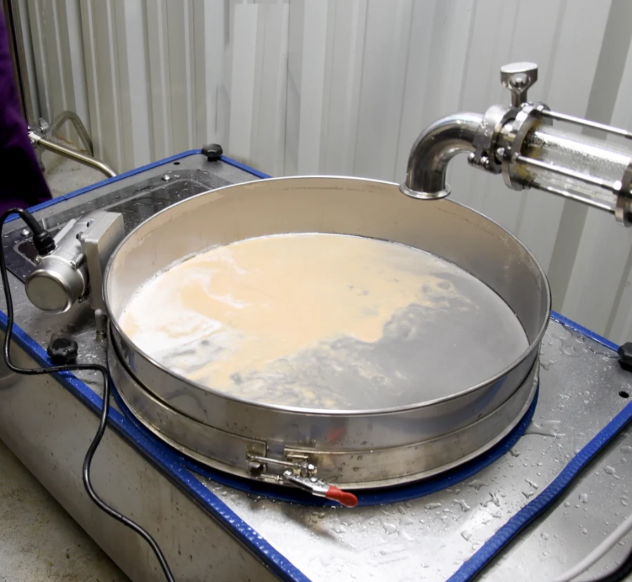 A sieve separates a light brown liquid from a darker liquid.