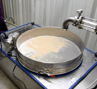 A sieve separates a light brown liquid from a darker liquid.