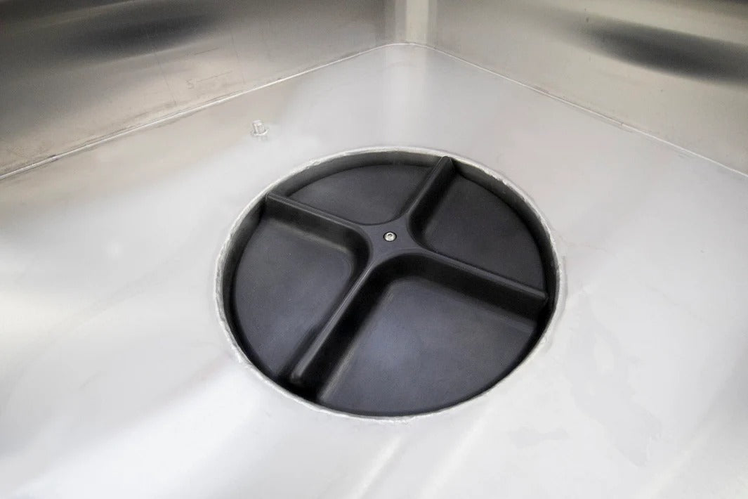 Close-up of stainless steel hash washing machine's circular drain with black separator.