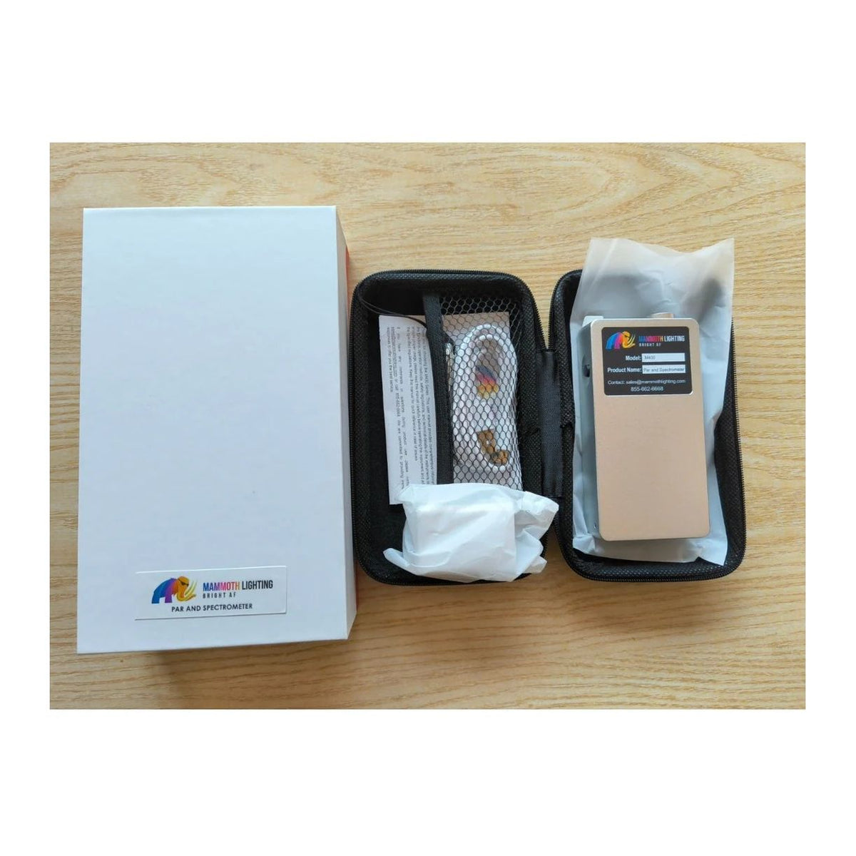Mammoth Lighting PAR and Spectrometer kit, including box, case with device, and accessories, on a wooden table.