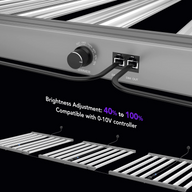 Close-up of a grow light's dimmer control and ports, with multiple lights in the background.