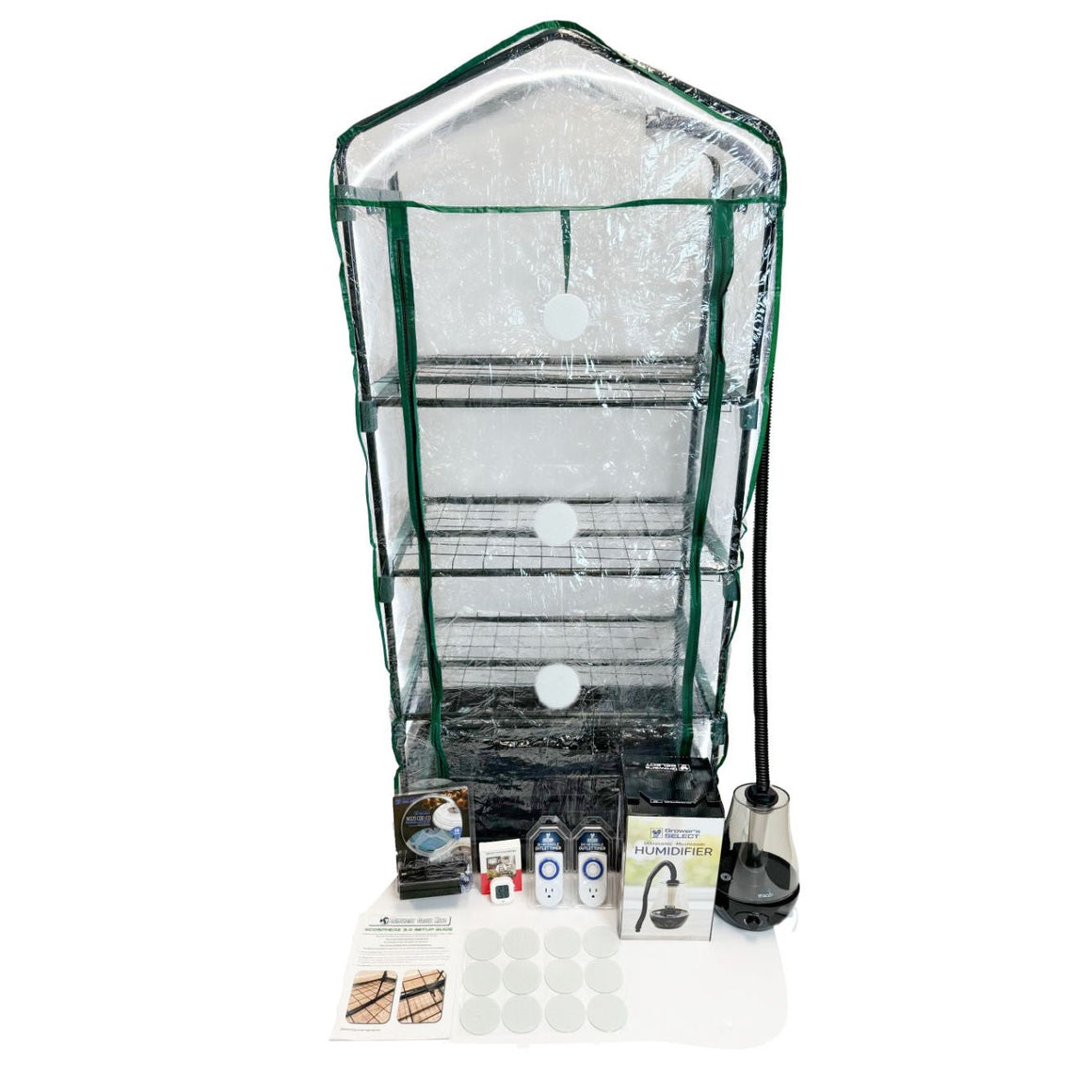 Clear plastic multi-tier mushroom grow tent with green frame, humidifier, timers, and kit accessories.