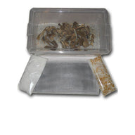 Mushroom drying kit: clear container with dried mushrooms, grey mesh mat, white & orange desiccant bags.