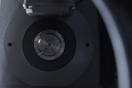 Close-up of a metal shredder aperture with circular cutting mechanism and engraved serial numbers.
