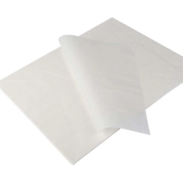 Stack of white parchment paper sheets with one sheet curling upwards, revealing its texture.