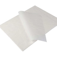 Stack of white parchment paper sheets with one sheet curling upwards, revealing its texture.