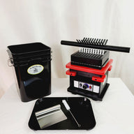 Black bucket, red and black pill press machine, black tray with scraper and brush.