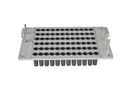 Close-up view of an aluminum capsule filling tray with rows of black rubber gaskets to hold capsules.