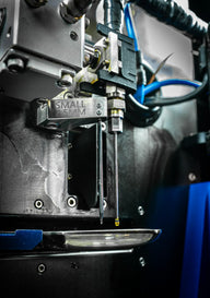 Robotic arm dispenses liquid from a nozzle with 