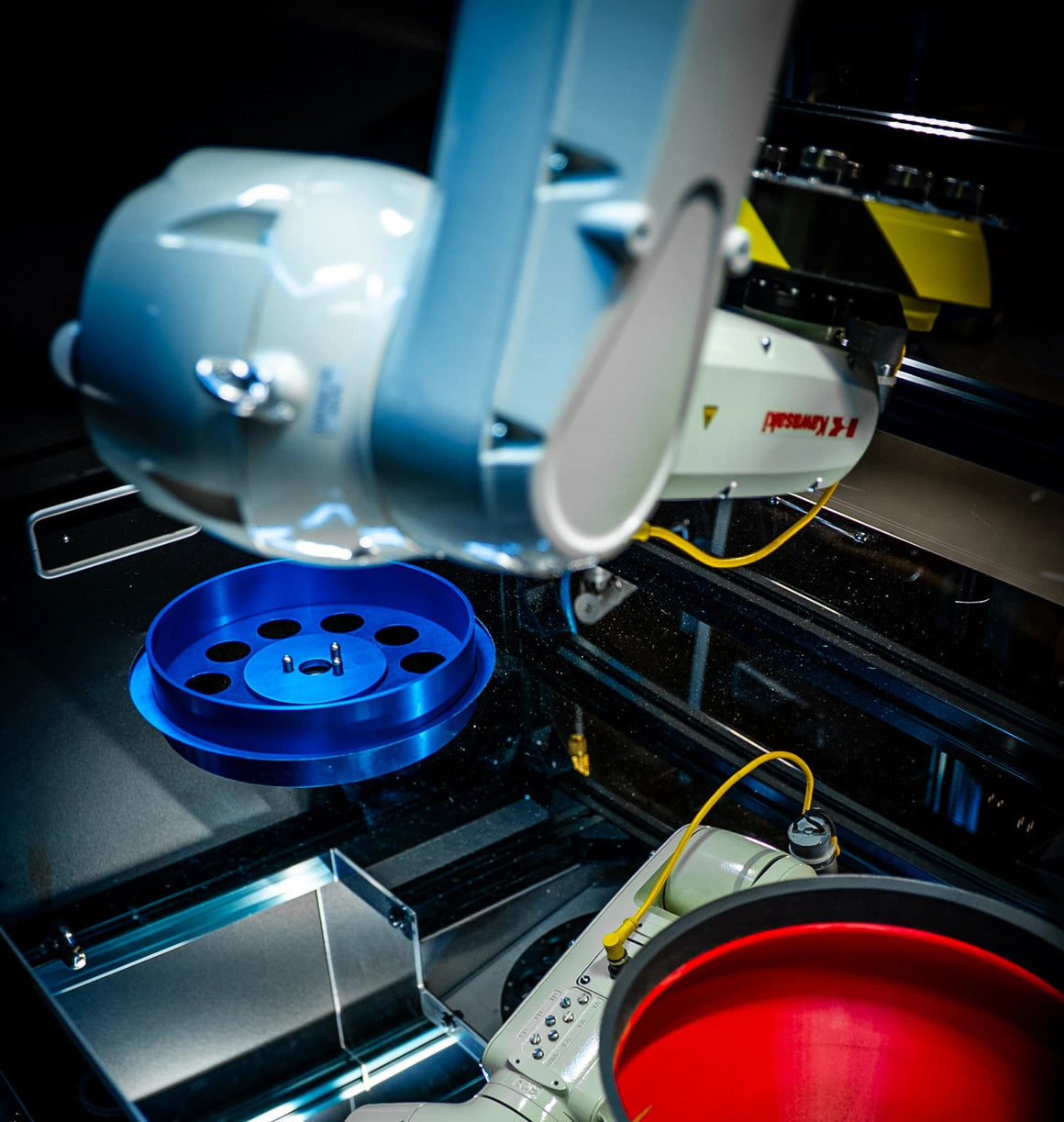 Kawasaki robot arm sorting in a lab with blue tray and red liquid container.
