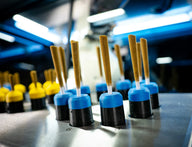 Brown cones with blue and black holders on a metal surface, illuminated by blue overhead lights.